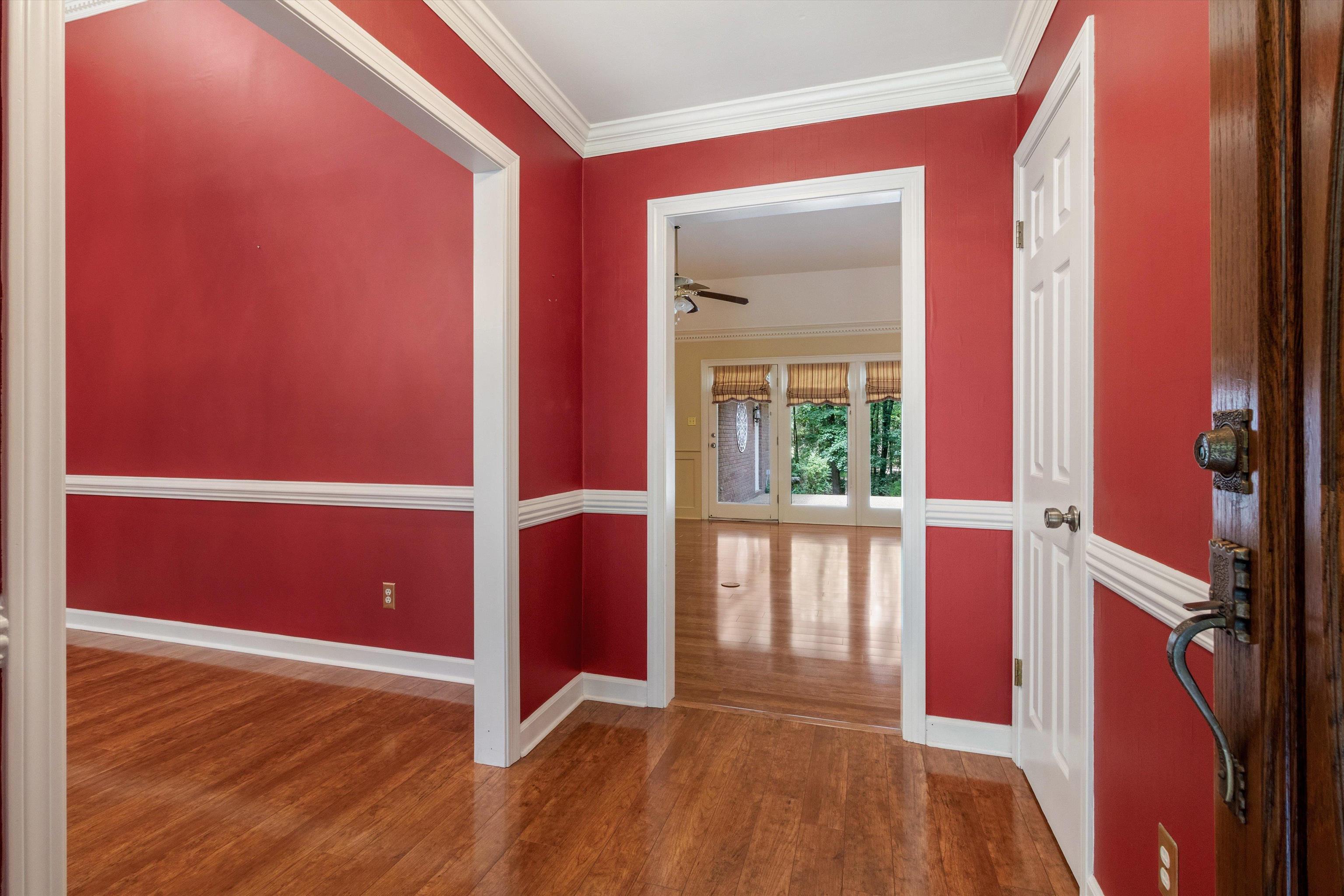 Entryway with wood finished floors, a ceiling fan, and crown molding