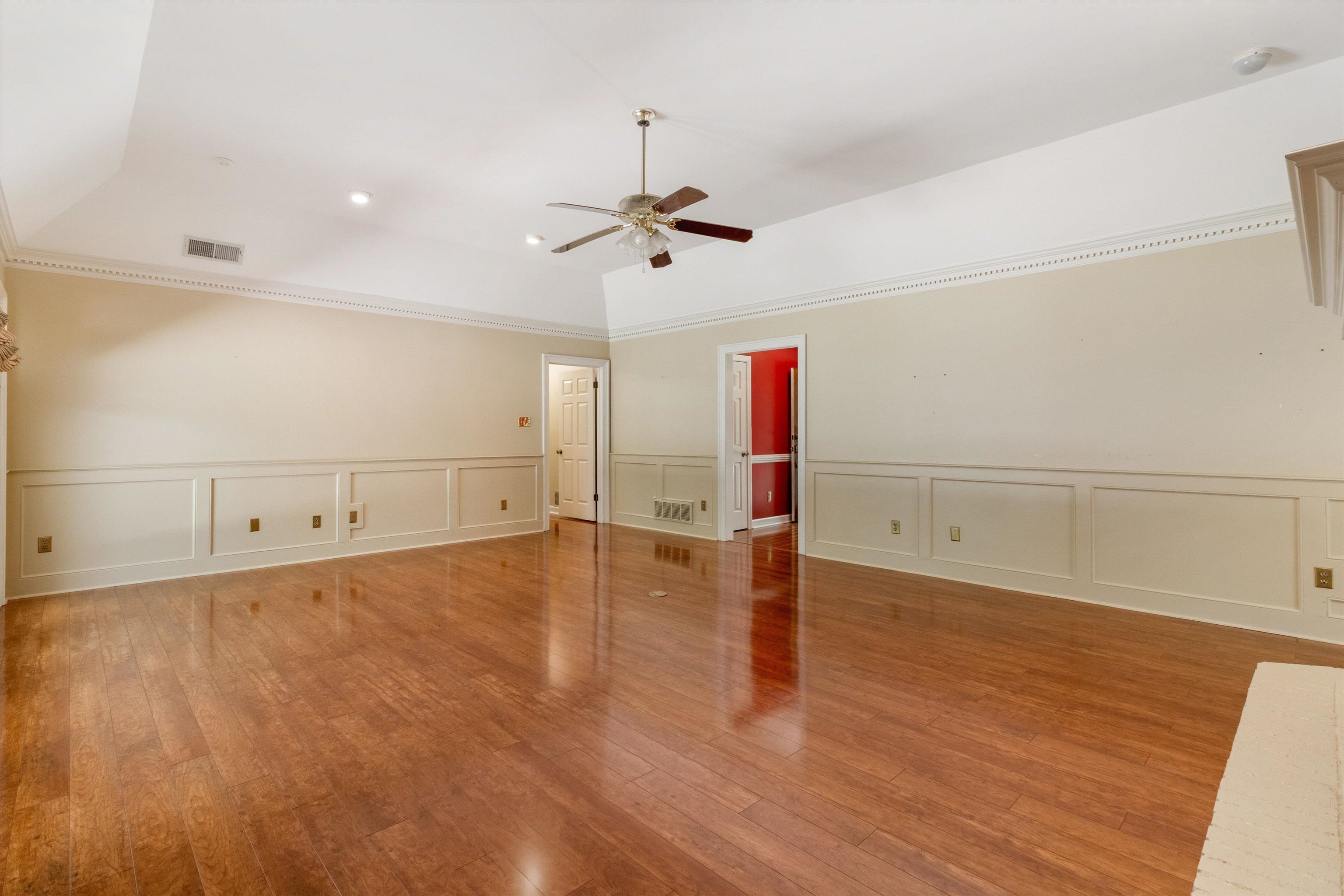 4081 Brunswick Road Bartlett, TN 38133 - Photo 8 of 31 Empty room featuring a ceiling fan, a decorative wall, wood finished floors, and wainscoting