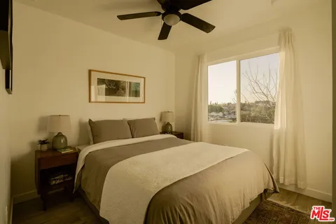 a bedroom with a bed and wooden floor
