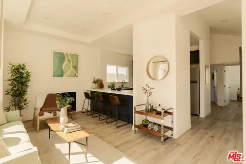 a living room with furniture a mirror and a wooden floor