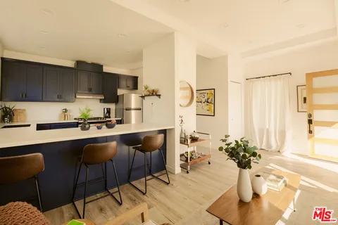 a kitchen with a table chairs in it and wooden floors
