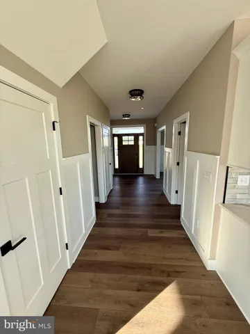 a view of a hallway with wooden floor and stairs