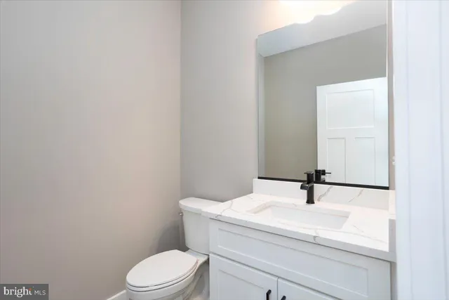 a bathroom with a sink a toilet and mirror