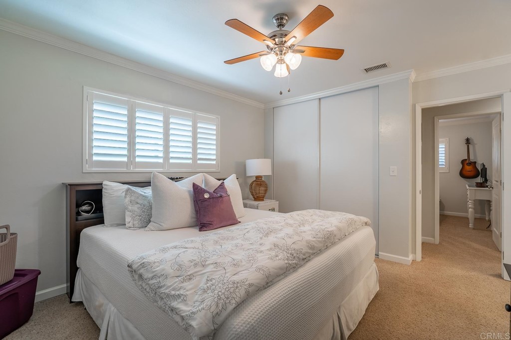 11493 Eucalyptus Hills Drive Lakeside, CA 92040 - Photo 20 of 30 a bedroom with a large bed and a chandelier