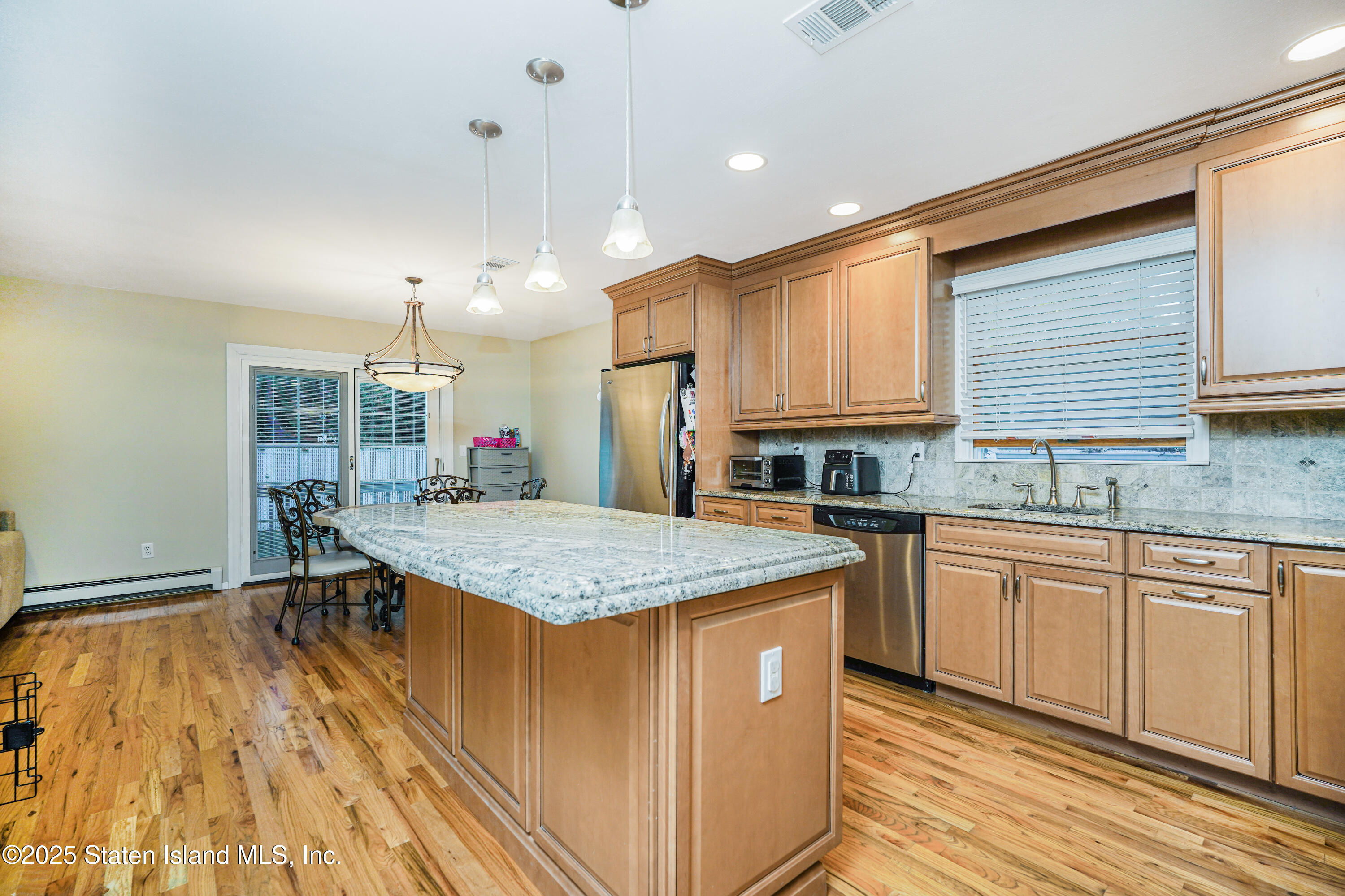 145 Shirley Avenue Staten Island, NY 10312 - Photo 11 of 29 a kitchen with stainless steel appliances granite countertop wooden cabinets a stove a sink and a wooden floors