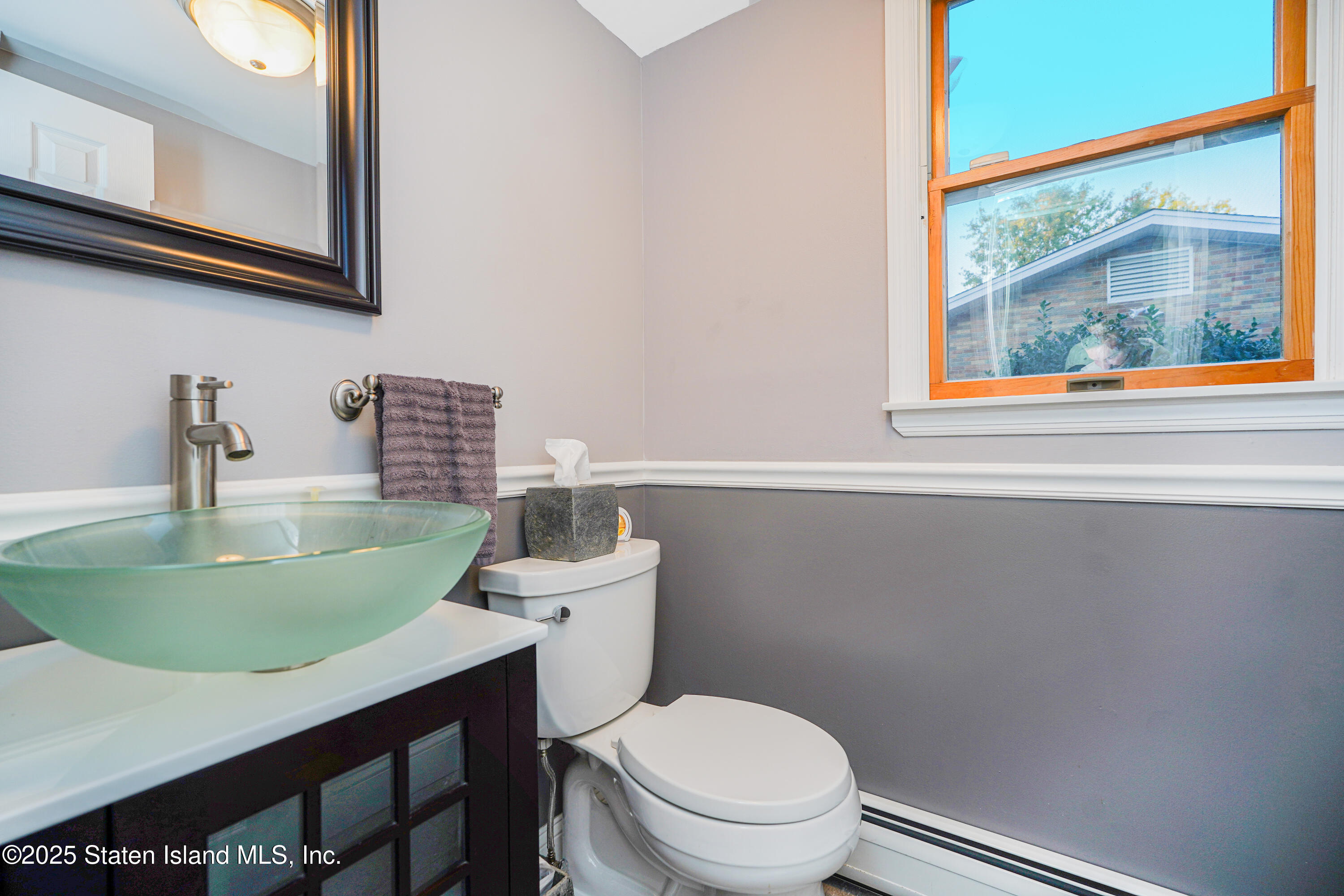145 Shirley Avenue Staten Island, NY 10312 - Photo 19 of 29 a bathroom with a toilet a sink and a mirror