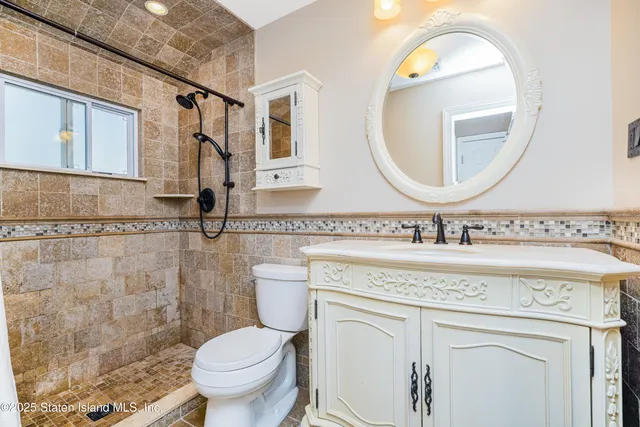 a bathroom with a granite countertop toilet sink and mirror