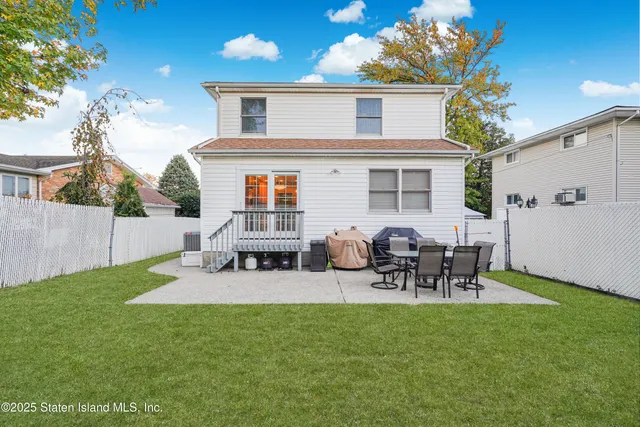 a view of a patio with table and chairs potted plants and large tree