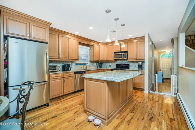 a kitchen with stainless steel appliances granite countertop a refrigerator a stove and a sink