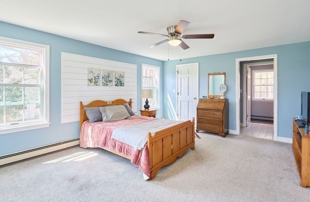 58 Buttercup Lane Hanover, MA 02339 - Photo 18 of 35 a spacious bedroom with a bed and a chandelier