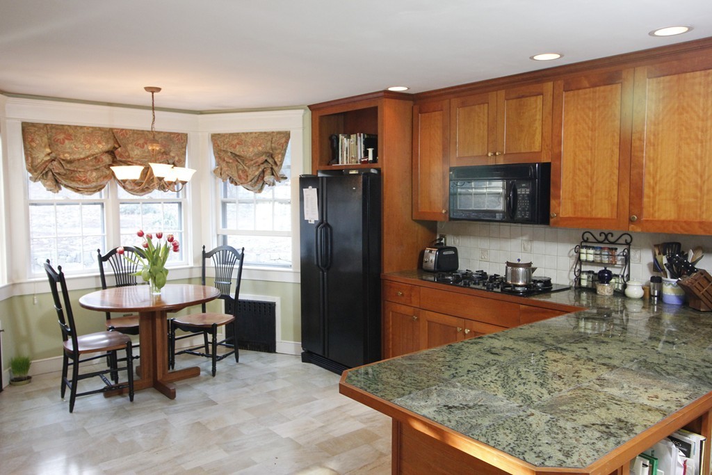 235 Haynes Road Sudbury, MA 01776 - Photo 8 of 24 a kitchen with stainless steel appliances granite countertop a refrigerator a stove top oven a sink and dining table