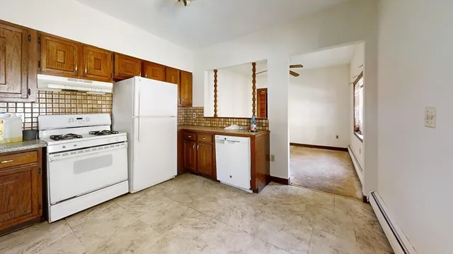 a kitchen with a refrigerator and white cabinets