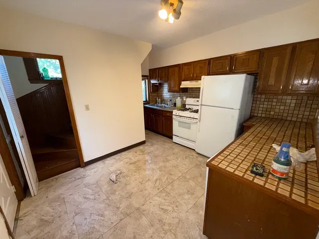 a kitchen with a refrigerator and a stove