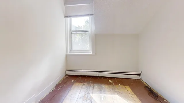 a view of a room with wooden floor and window
