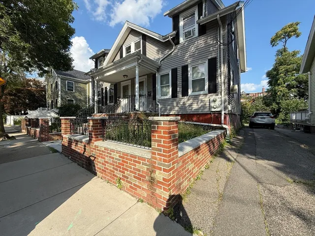 a view of a white house with couches and chairs