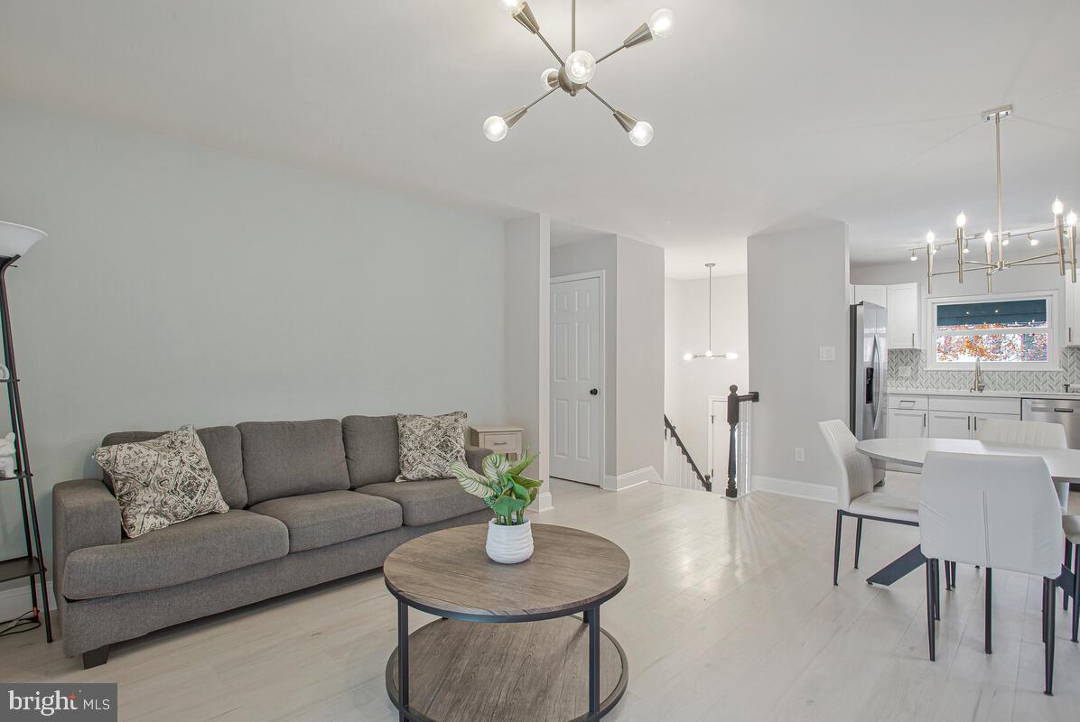 267 Lake Riviera Road Pasadena, MD 21122 - Photo 11 of 34 a living room with furniture and a dining table with kitchen view