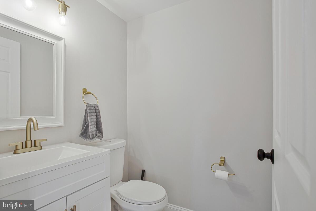267 Lake Riviera Road Pasadena, MD 21122 - Photo 23 of 34 a bathroom with a toilet sink vanity and mirror