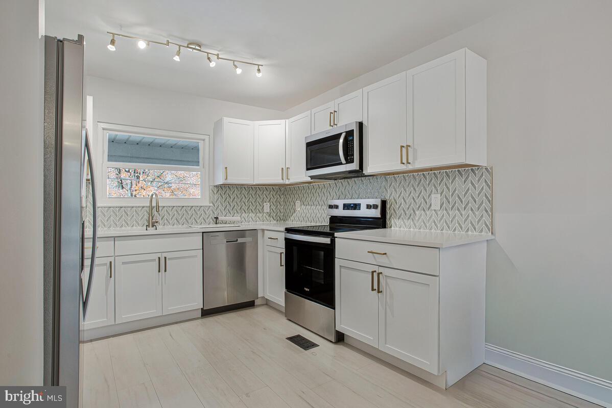 267 Lake Riviera Road Pasadena, MD 21122 - Photo 3 of 34 a kitchen with white cabinets and white appliances