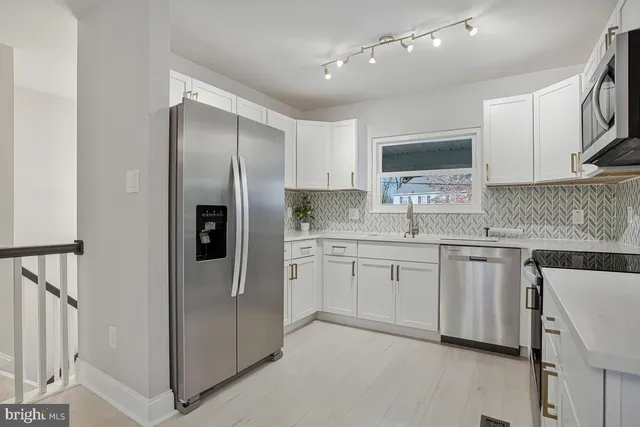 a kitchen with stainless steel appliances granite countertop a refrigerator and a stove top oven