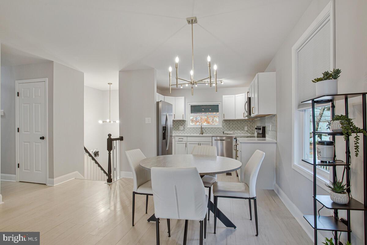 267 Lake Riviera Road Pasadena, MD 21122 - Photo 10 of 34 a view of a dining room and livingroom with furniture wooden floor a chandelier