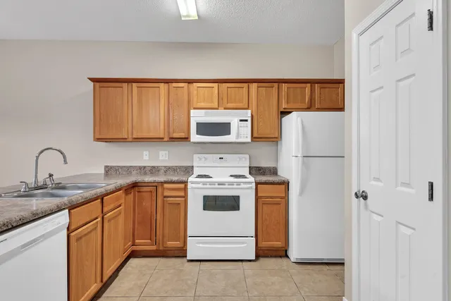 a kitchen with a white stove top oven and refrigerator