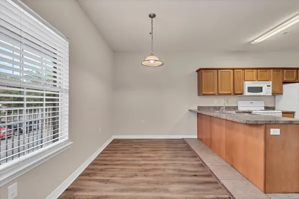 a kitchen with granite countertop a stove a sink and a window