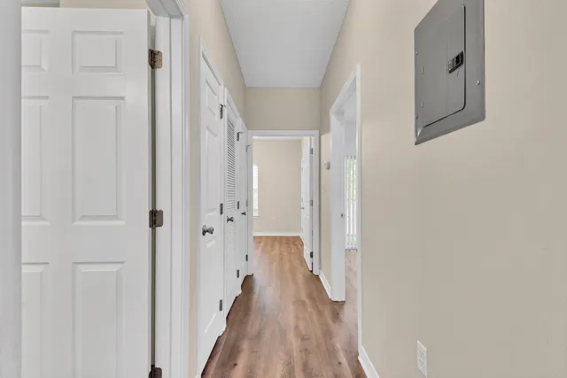 a view of a hallway with wooden floor and staircase