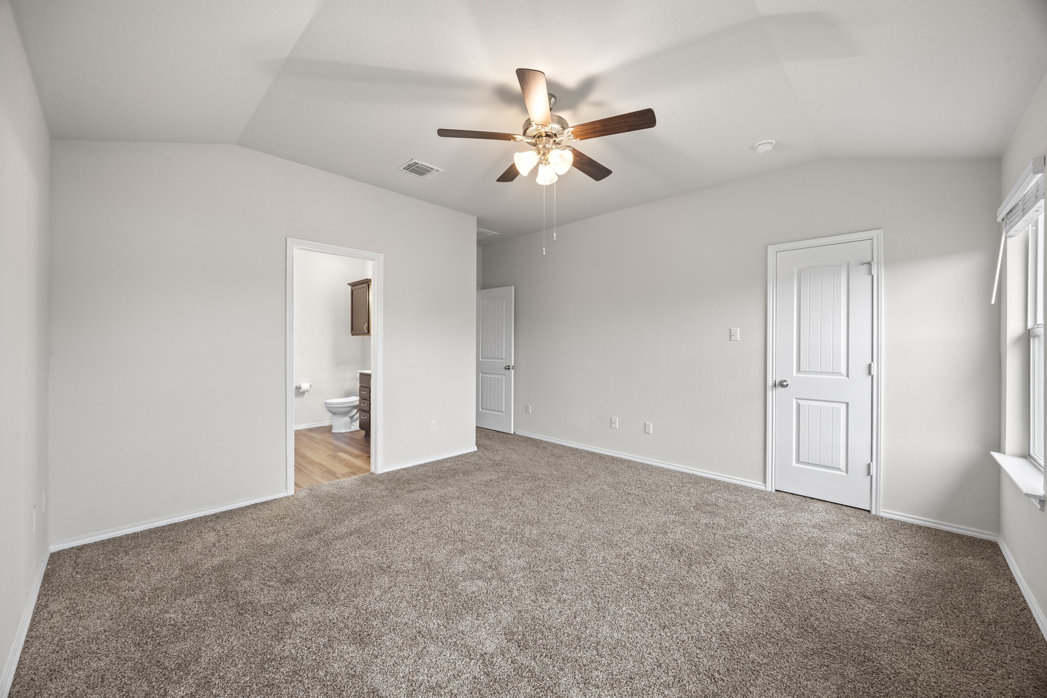 109 Gunther Way Taylor, TX 76574 - Photo 14 of 29 Carpeted room featuring a vaulted ceiling and a ceiling fan with integrated lighting