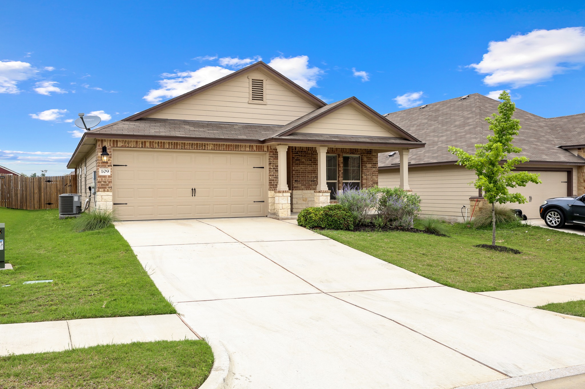 109 Gunther Way Taylor, TX 76574 - Photo 2 of 29 Single-story residence featuring a brick and siding exterior, an attached two-car garage, and a covered front porch with columns