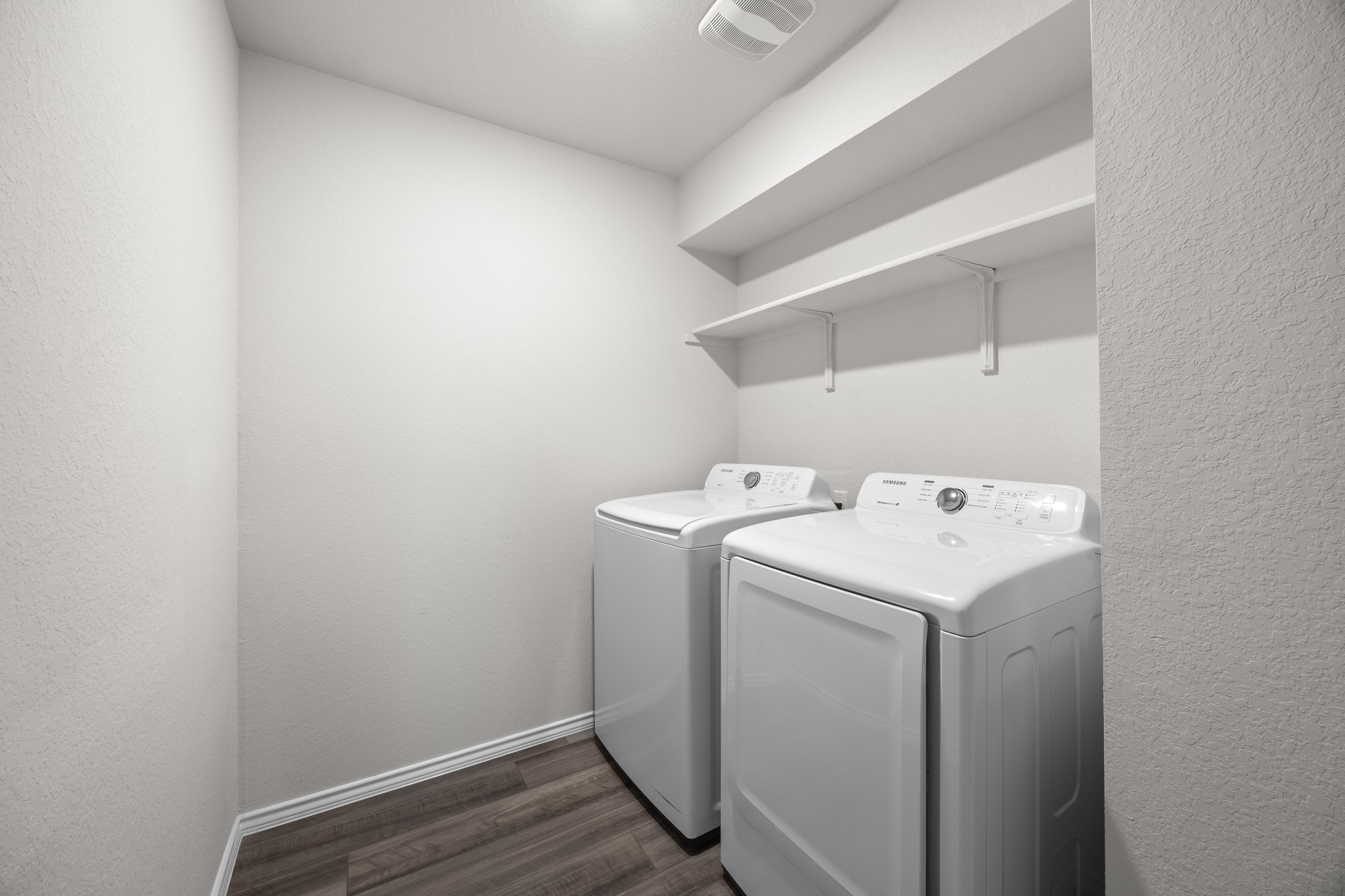 109 Gunther Way Taylor, TX 76574 - Photo 24 of 29 Dedicated laundry area with a washer and dryer, wood-finish flooring, white baseboards, wall-mounted shelving, and overhead lighting