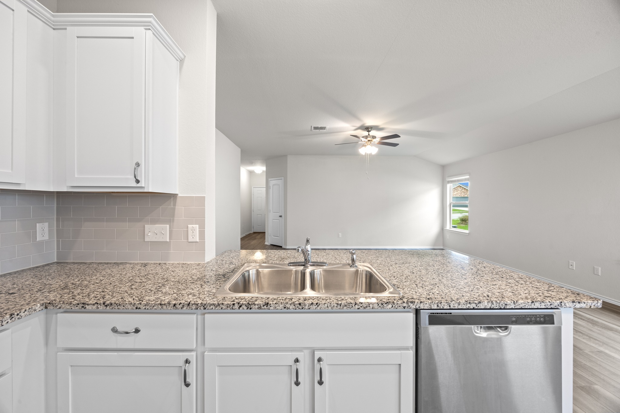 109 Gunther Way Taylor, TX 76574 - Photo 10 of 29 Kitchen featuring white cabinetry, speckled countertops, a double basin sink, and a stainless steel dishwasher