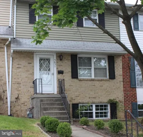 a front view of a house with plants