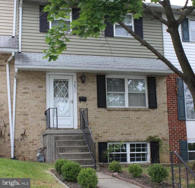 a front view of a house with plants