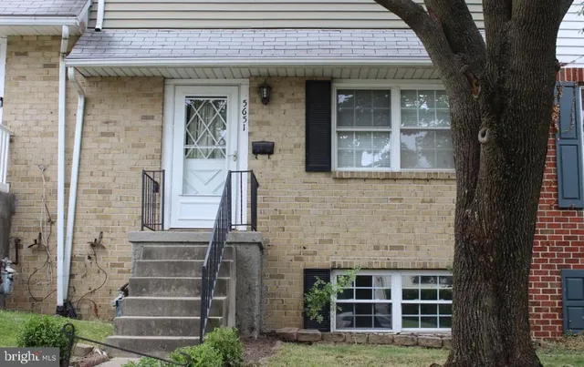 front view of a brick house with a small yard