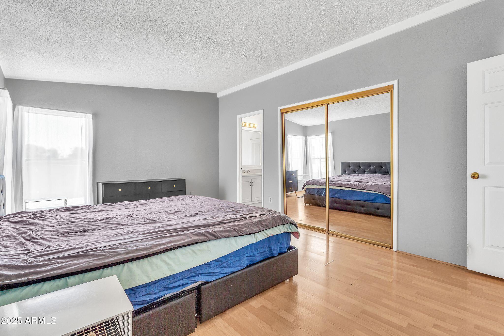 625 West McKellips Road, Unit 399 Mesa, AZ 85201 - Photo 18 of 31 a bedroom with a bed and wooden floor