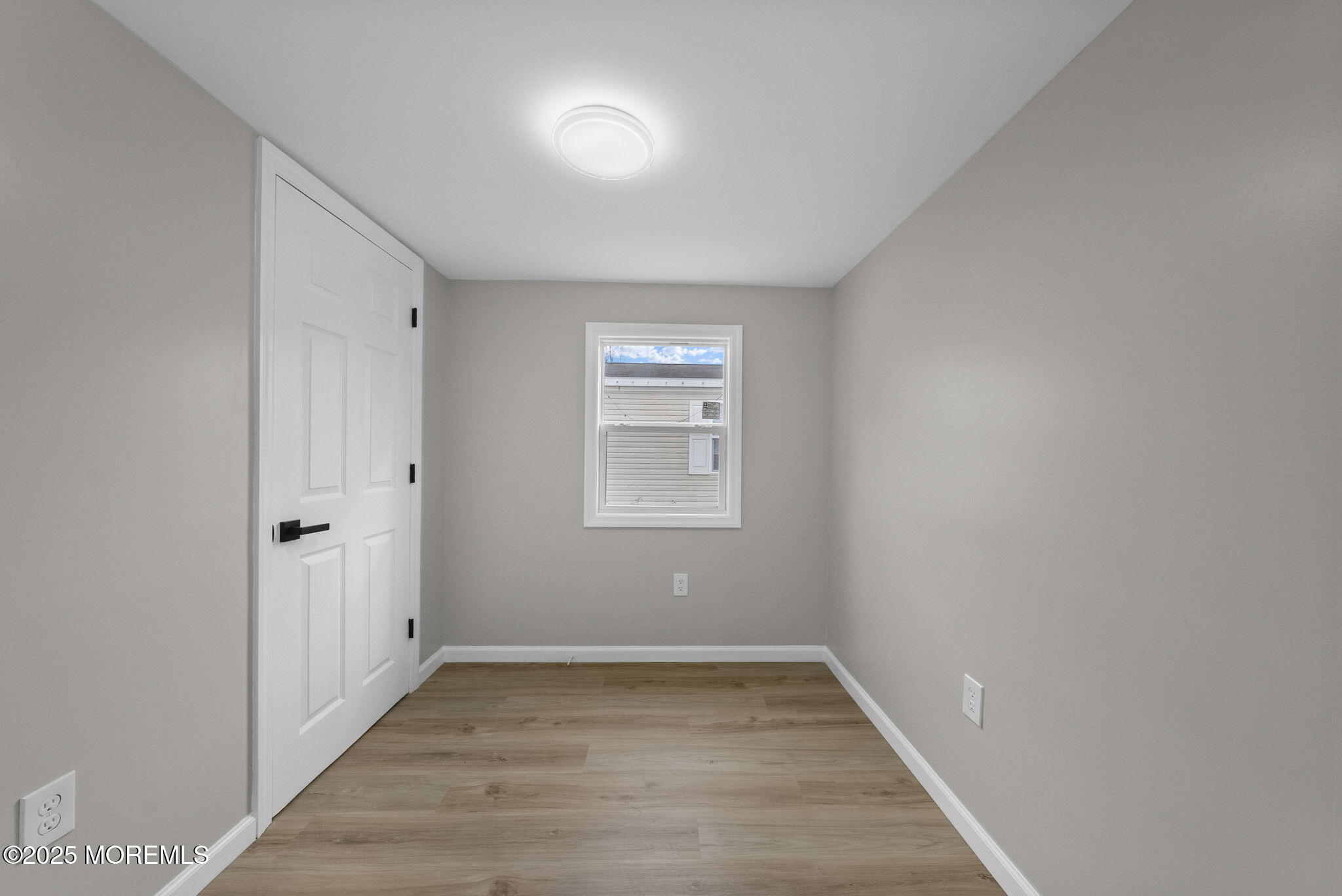 712 7th Street Jackson, NJ 08527 - Photo 17 of 37 a view of an empty room with wooden floor and a window