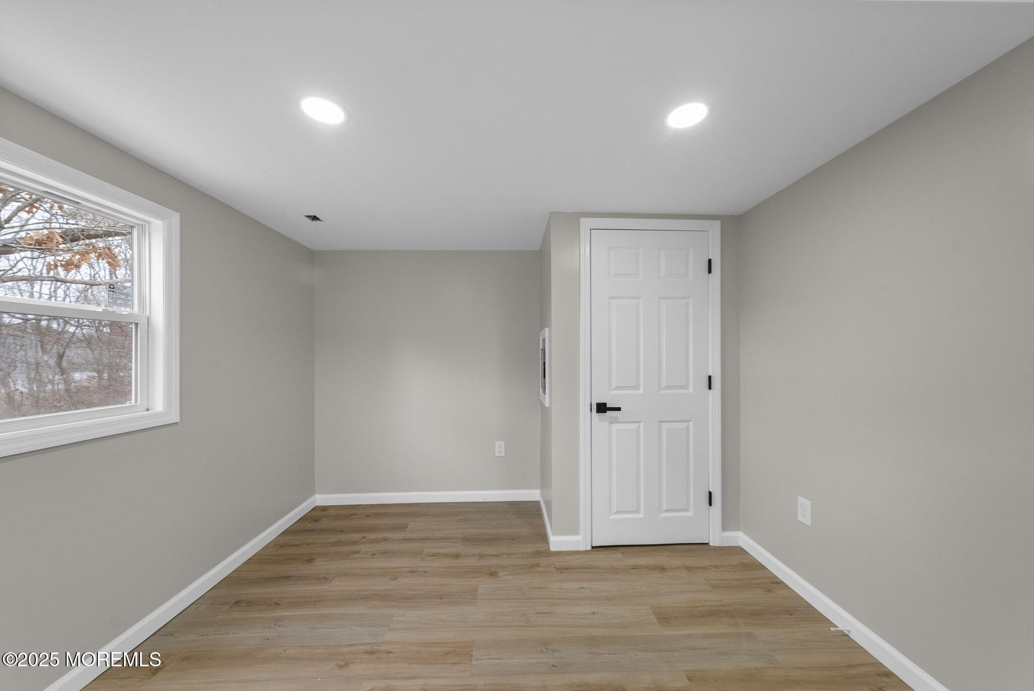 712 7th Street Jackson, NJ 08527 - Photo 24 of 37 a view of an empty room with wooden floor and a window