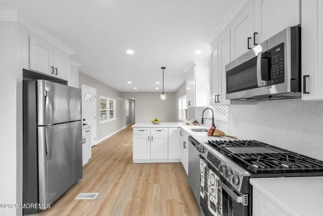 a kitchen with stainless steel appliances a refrigerator sink and cabinets