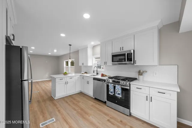 a kitchen with a refrigerator and a stove top oven