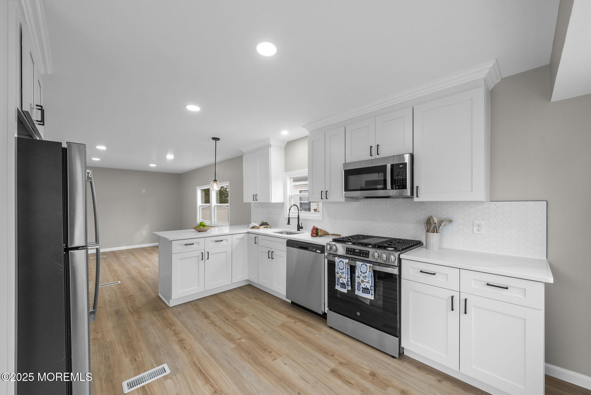 712 7th Street Jackson, NJ 08527 - Photo 10 of 37 a kitchen with stainless steel appliances granite countertop a stove top oven a sink dishwasher and a refrigerator with wooden floor