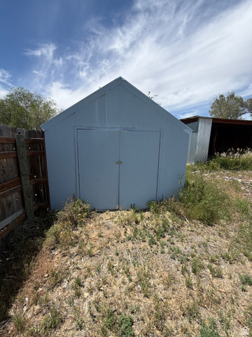 1043 East 4000th Street South Vernal, UT 84078 - Photo 8 of 31 Light blue storage shed with a gable roof and double doors