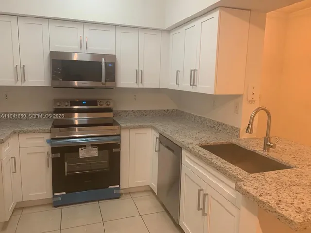 a kitchen with granite countertop a stove and a sink