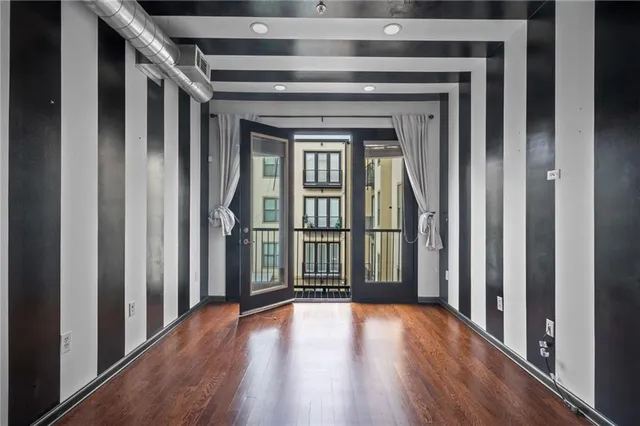 a view of a hallway with wooden floor and staircase