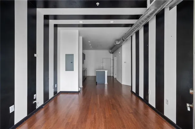 a view of a hallway with wooden floor and staircase