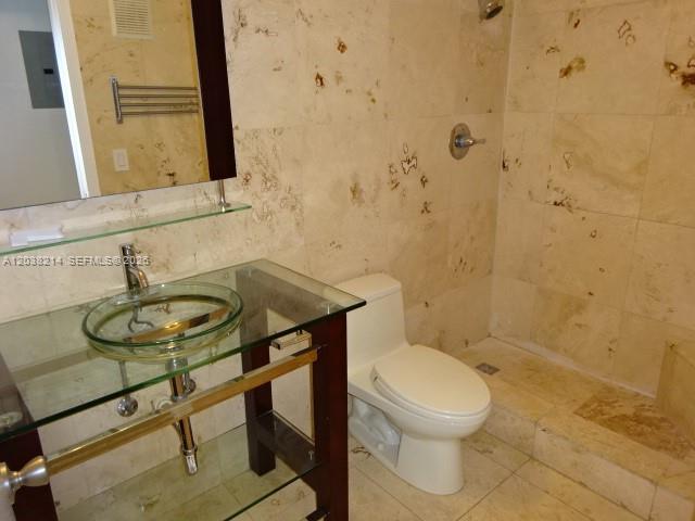 9727 Hammocks Boulevard, Unit 101D Miami, FL 33196 - Photo 8 of 12 a bathroom with a sink a toilet and a mirror