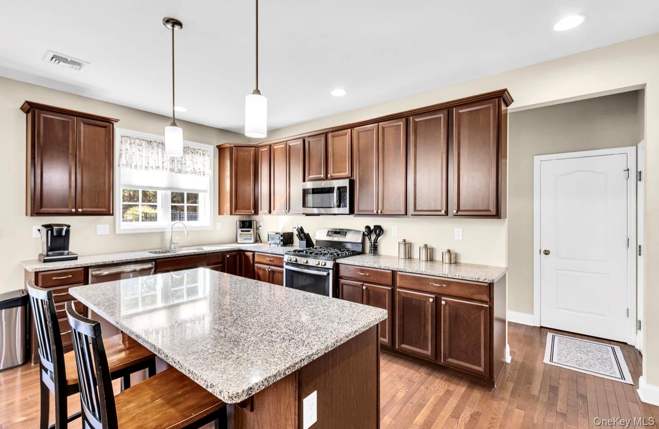 59 Luthien Forrest Road Rock Tavern, NY 12575 - Photo 13 of 48 a kitchen with stainless steel appliances granite countertop wooden cabinets a stove a sink and dishwasher