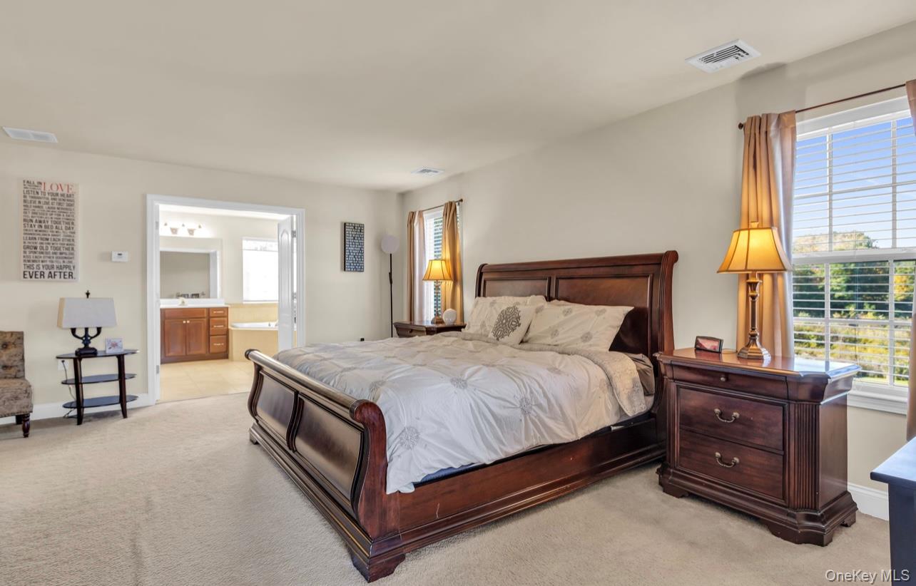 59 Luthien Forrest Road Rock Tavern, NY 12575 - Photo 24 of 48 a spacious bedroom with a bed and large windows