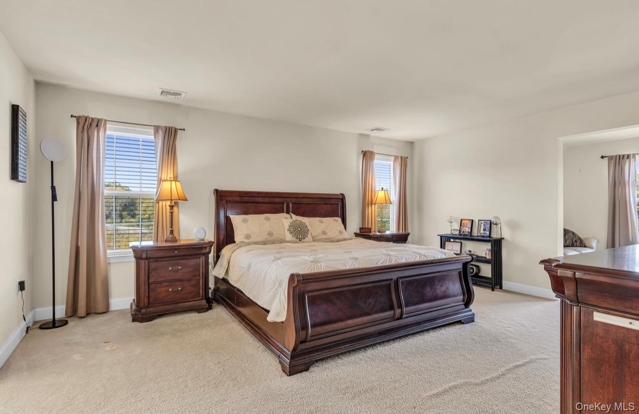 59 Luthien Forrest Road Rock Tavern, NY 12575 - Photo 25 of 48 a spacious bedroom with a bed and a chandelier