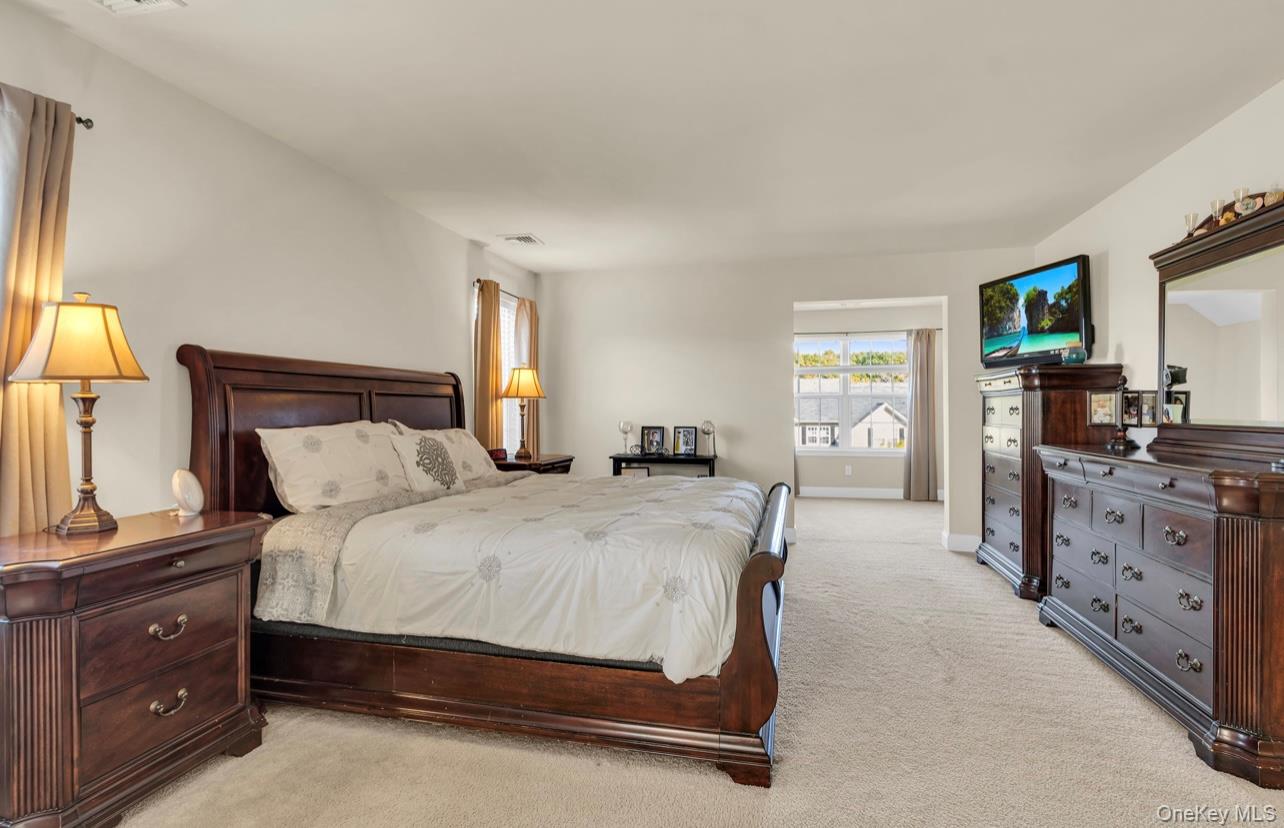 59 Luthien Forrest Road Rock Tavern, NY 12575 - Photo 26 of 48 a bedroom with a bed and a flat tv screen on dresser