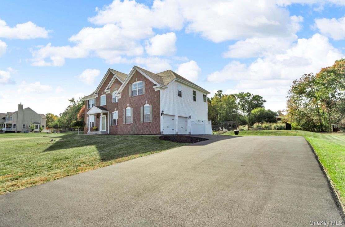 59 Luthien Forrest Road Rock Tavern, NY 12575 - Photo 3 of 48 a front view of a house with a yard and garage